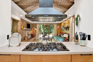 a kitchen with a stove and a living room at Midcentury Modern - Pool & Hot tub - Retro Retreat in Mobile