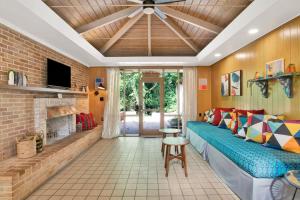 a living room with a blue couch and a fireplace at Midcentury Modern - Pool & Hot tub - Retro Retreat in Mobile