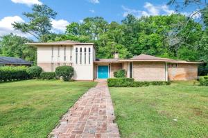 una casa con una entrada de ladrillo frente a un patio en Midcentury Modern - Pool & Hot tub - Retro Retreat en Mobile