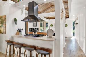 a kitchen with a island with a stove and stools at Midcentury Modern - Pool & Hot tub - Retro Retreat in Mobile