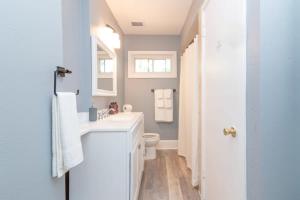 a bathroom with a white sink and a toilet at Large Yard with Treehouse Tri-Level Retreat in Columbus