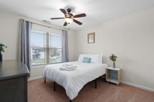 een slaapkamer met een bed, een plafondventilator en een raam bij The Beds on Brewster- 15 mins to Ft Campbell in Oak Grove