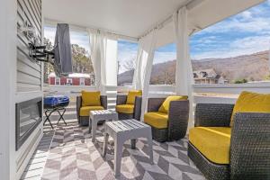 uma sala de estar com cadeiras e uma televisão e janelas em Petite Retreat by Green Mountain - Cozy Byrd Nest em Owens Cross Roads