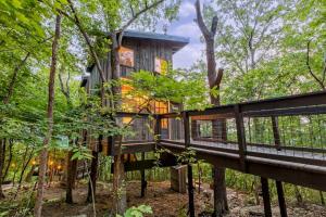 una casa en el bosque con un puente en Treetop Hideaways: The Dogwood Treehouse, en Chattanooga