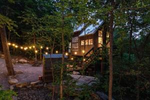 a tree house in the middle of the woods at night at Treetop Hideaways: The Redbud Treehouse in Chattanooga
