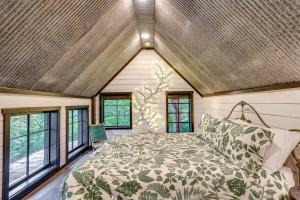 a bedroom with a large bed in a room with windows at Treetop Hideaways: The Wood Lily Treehouse in Chattanooga