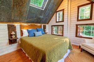 a bedroom with a bed in a room with windows at Treetop Hideaways: The Redbud Treehouse in Chattanooga