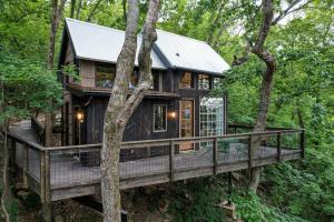 domek na drzewie w lesie z dużym tarasem w obiekcie Treetop Hideaways: The Wood Lily Treehouse w mieście Chattanooga
