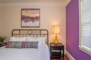 1 dormitorio con paredes moradas y 1 cama con lámpara en Boho Vibes - Spacious in the Heart of Downtown, en Augusta