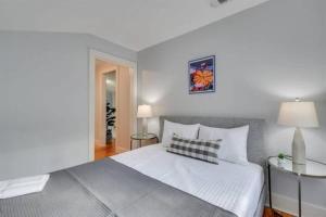 een slaapkamer met een wit bed en 2 tafels bij Covered in Sunshine in Midtown Augusta in Augusta