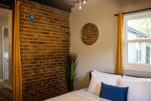 a bedroom with a brick wall and a bed at The Cozy Getaway Grill & Roku at Your Convenience! in Huntsville