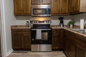 a kitchen with a stove and a microwave at The Cozy Getaway Grill & Roku at Your Convenience! in Huntsville