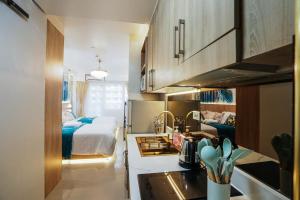a kitchen with a bed and a kitchen with a sink at Hawaii Suite by Guest Reservations Manila in Manila