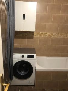 a washing machine in a bathroom next to a bath tub at Appartement avec terrasse in Saint-Ouen