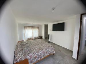 a bedroom with a bed and a flat screen tv at Hospedaje Feria de San marcos 2024 Para 8 Personas in Aguascalientes
