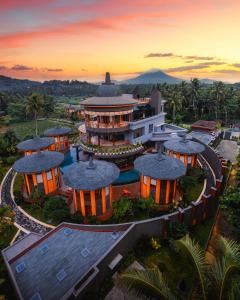 una vista aérea de un edificio con una puesta de sol en el fondo en Hotel Le Temple Borobudur en Borobudur