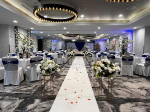 a banquet hall with tables and chairs and a aisle with flowers at Holiday Inn Manchester - City Centre by IHG in Manchester