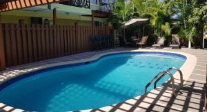 une grande piscine dans une cour avec une clôture dans l'établissement Di Villa, à Port Antonio
