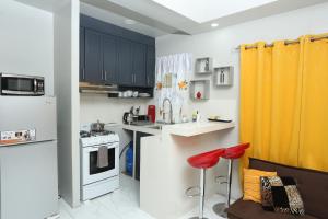 a kitchen with black cabinets and a yellow curtain at Home Away From Home in Kingston