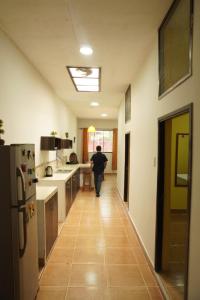 a man walking down a hallway in a kitchen at HABITACIONES PRIVADAS in Tarapoto