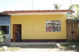 a man standing in the door of a yellow house at HABITACIONES PRIVADAS in Tarapoto