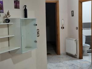 ein Badezimmer mit einem Glasschrank und einem WC in der Unterkunft Panorama III Cliniques les Jasmins in Ariana