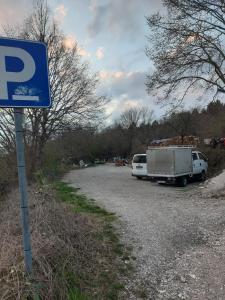 un parking avec un panneau de stationnement et un camion dans l'établissement Rooms with a parking space Jelovice, Central Istria - Sredisnja Istra - 22787, à Lanišće