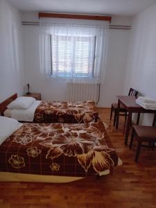 - une chambre avec 2 lits, une table et une fenêtre dans l'établissement Rooms with a parking space Jelovice, Central Istria - Sredisnja Istra - 22787, à Lanišće