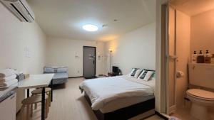 ein kleines Zimmer mit einem Bett und einem Badezimmer in der Unterkunft 難波南34 in Osaka