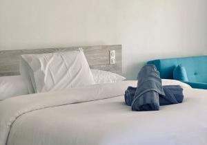 1 Schlafzimmer mit einem weißen Bett und einem blauen Kopfteil in der Unterkunft Mareta Lodge - Studio TORU 3 in Bora Bora