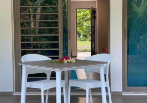 ein weißer Tisch und Stühle mit Blumen darüber in der Unterkunft Mareta Lodge - Studio TORU 3 in Bora Bora