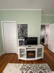 uma sala de estar com televisão e lareira em It’s Showtime-Book Lally’s House! Steps to Common! em Salem