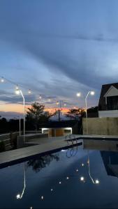 una piscina con puesta de sol en el fondo en Villa Cijeruk Village, en Cihideung