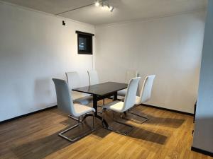 une salle de conférence avec une table noire et des chaises blanches dans l'établissement Novkrokene - Spacious and fully equipped 3 beds apartment with free parking, à Stavanger