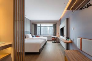 a hotel room with two beds and a window at Holiday Inn Express Jiangmen East Station by IHG in Jiangmen +53 photos