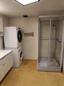 uma casa de banho com um chuveiro e uma máquina de lavar roupa em Novkrokene - Spacious and fully equipped 3 beds apartment with free parking em Stavanger