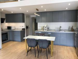 a kitchen with blue cabinets and a table and chairs at Appartement d'architecte en extra centre de Saint Denis in Saint-Denis