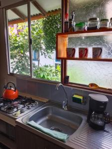 a kitchen with a sink and a stove and a window at Apartaestudios La Baranda in Salento