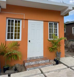 a small orange house with a white door at Home Away From Home in Kingston