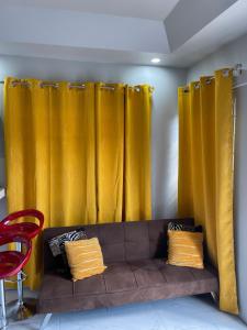 a couch in a room with yellow curtains at Home Away From Home in Kingston