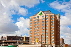 a hotel with a green sign on the top of it at Holiday Inn & Suites Winnipeg Downtown, an IHG Hotel in Winnipeg