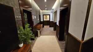 um corredor de um escritório com plantas e um corredor com um corredor de um corredor de um lado de outro em رحال البحر للشقق المخدومة Rahhal AlBahr Serviced Apartments em Jeddah