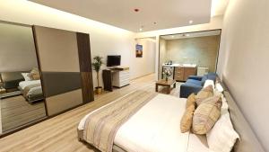 een hotelkamer met een bed en een woonkamer bij رحال البحر للشقق المخدومة Rahhal AlBahr Serviced Apartments in Jeddah