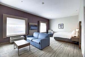 カルガリーにあるHoliday Inn Express Airport Calgary by IHGのベッドとソファのあるホテルの部屋