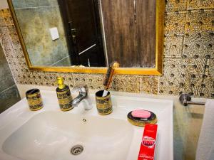 um lavatório de casa de banho com duas chávenas e um espelho em Bahria Town Lahore Prestige Apartments by LMY em Lahore
