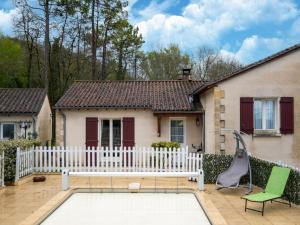 uma casa com uma cerca branca e um baloiço em Charming holiday home in Sarlat-la-Canéda em Sarlat-la-Canéda