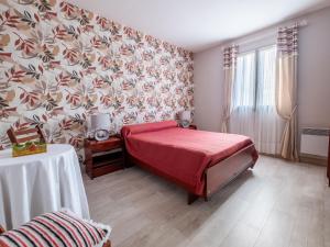 um quarto com uma cama vermelha e papel de parede floral em Charming holiday home in Sarlat-la-Canéda em Sarlat-la-Canéda