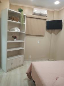 - une chambre avec une étagère et un lit dans l'établissement Apartamento Studio Central, à Navegantes