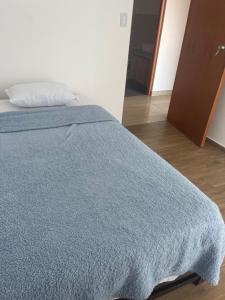 a bed with a blue blanket on top of it at Departamento 401 - NAREA in Pimentel