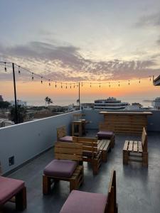 a rooftop patio with benches and a view of a ship at Departamento 401 - NAREA in Pimentel